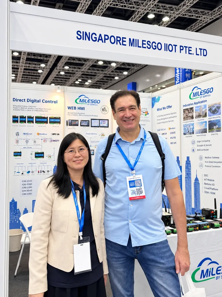 A visitor with a member of the MILESGO team in front of Direct Digital Control, Web HMI and industry application displays at the MILESGO by Sunfull booth.